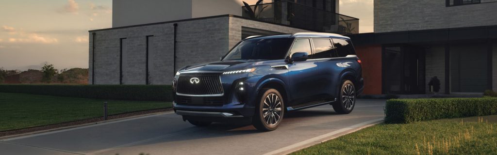 Blue Infiniti QX80 parked in a modern driveway.