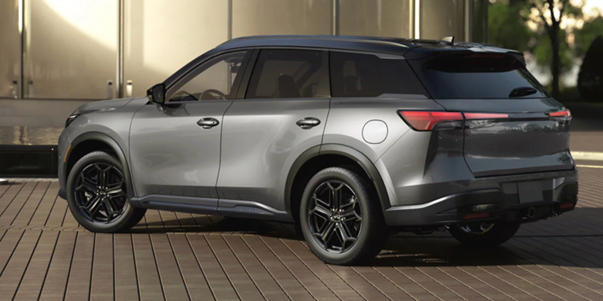new INFINITI SUV, dark gray, parked on a brick drive